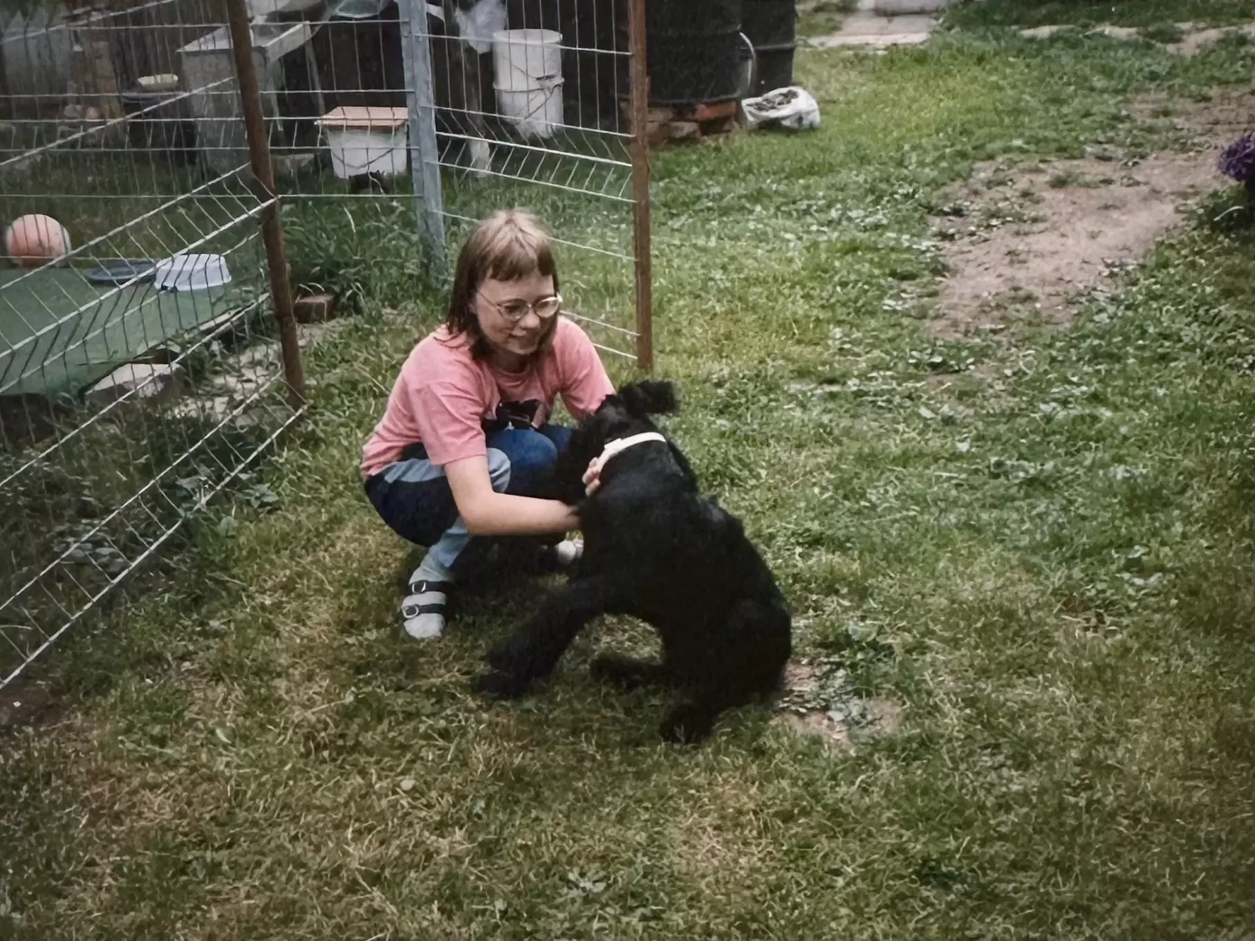Daniela als Kind mit schwarzem Riesenschnauzer namens Bessy im Garten